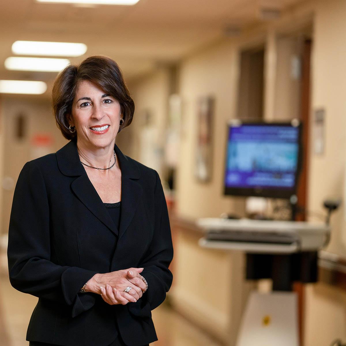 Photo of Sandra Rader smiling in a hospital corridor